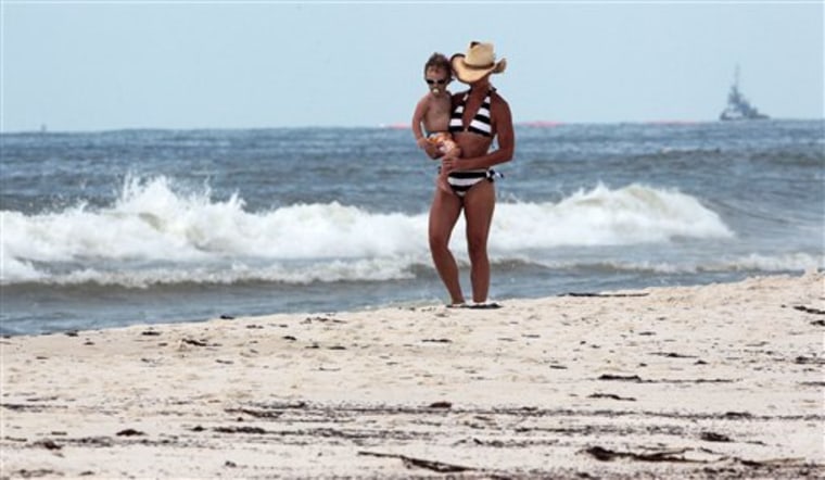 Julie Riekhof carries her son Christian, 2, down the oily beach in Perdido Key, Fla., Friday.